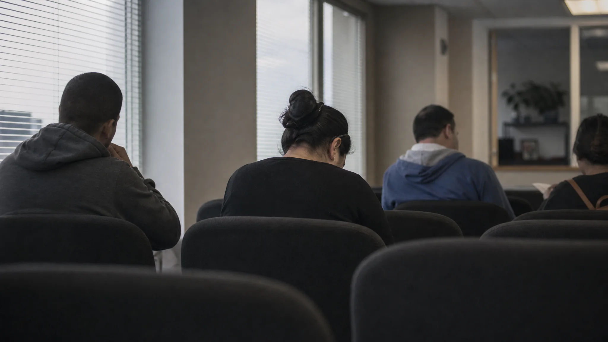 A staffing agency waiting area with seated candidates